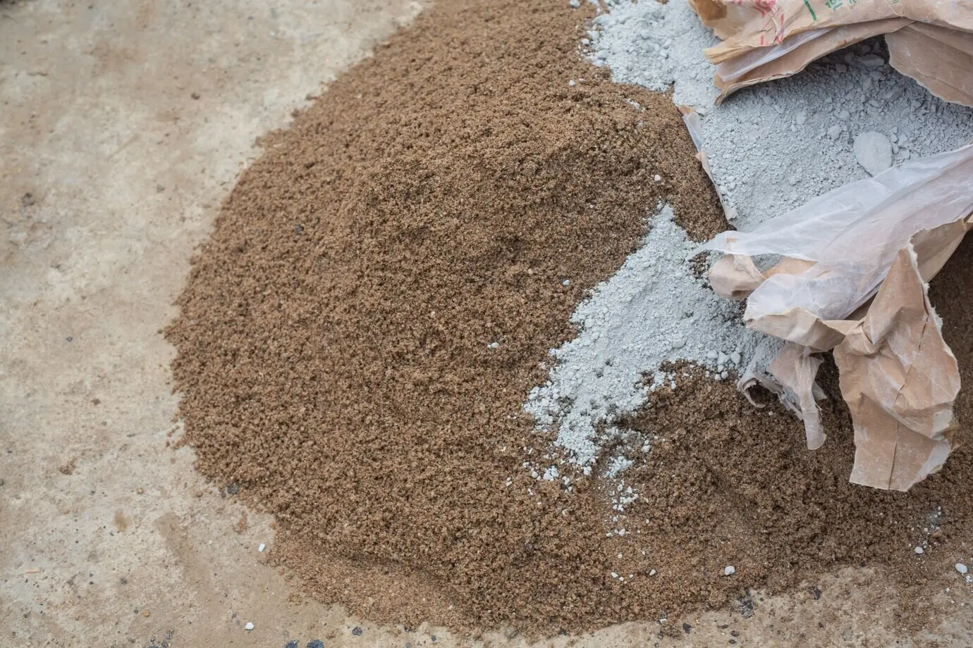Construction technicians are combining cement, stone, and sand for construction.