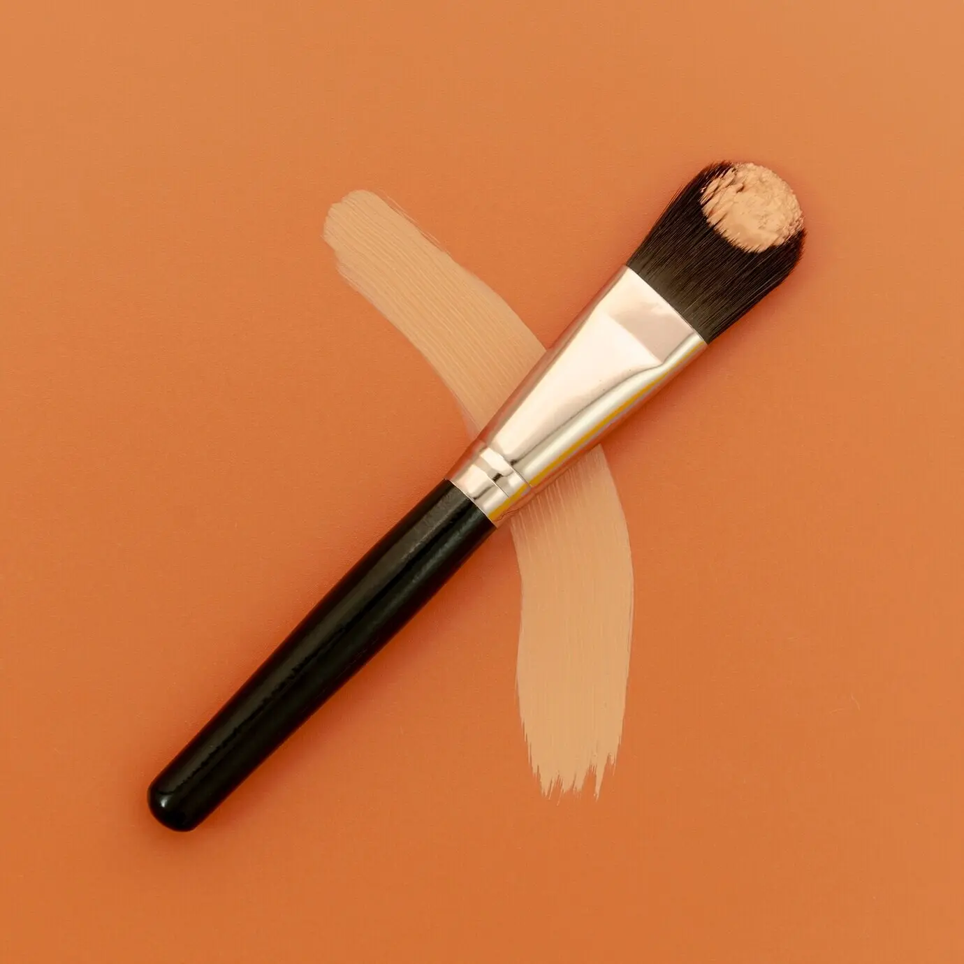 A foundation brush against a brown background.